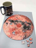 A uniqe round Mars puzzle made from wood, with oddly shaped pieces including special pieces an alien, Curiosity Rover, a spaceship and more! A round space-themed planet puzzle gift.