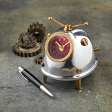 A cute space alien clock for your desk or table, by Pendulux with an aluminum and brass body, and a red face, with antennae on top to look like a bug!