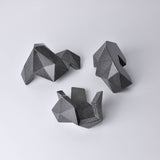 A black/dark gray, abstract geometric desk object/organize with a space-theme, resembling space rocks on the surface of a moon or planet. An interesting space-themed gift!