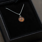 A gift box holding a sterling silver pendant space necklace with genuine Martian Mars meteorite dust inside! Space jewelry at its finest.