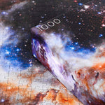 Nebula puzzle - 1000 piece rectangular galaxy space puzzle - showing corner of box with puzzle pieces in background