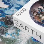 Round Earth Puzzle - 1000 piece planet space jigsaw puzzle - corner of box with puzzle pieces in background