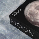 Round Moon Puzzle - 1000 piece space jigsaw puzzle - corner of box with puzzle pieces in background