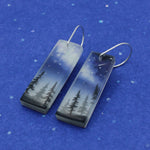 Starry night sky space jewelry earrings with milky way and forest trees scene.