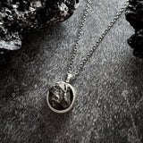 A beautiful and unique small round chunky raw meteorite necklace in a silver tone deep bezel. The perfect space-themed necklace jewelry gift!