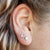 A cute mismatched pair of sterling silver moon and star stud earrings - the perfect space jewelry gift for a space lover! Showing them on an ear.