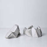 A white, abstract geometric desk object with a space-theme, resembling space rocks on the surface of a moon or planet. An interesting space-themed gift!
