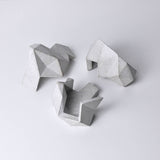 A white, abstract geometric desk object with a space-theme, resembling space rocks on the surface of a moon or planet. An interesting space-themed gift!