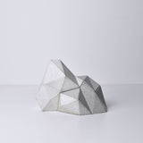 A white, abstract geometric desk object with a space-theme, resembling space rocks on the surface of a moon or planet. An interesting space-themed gift!