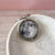 A spinning Moon fidget keychain with a full moon on one side and new moon on the other side under glass. A fun space moon keychain gift for men or women!