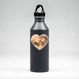 A vinyl heart moon sticker shown on a water bottle, perfect for any lover of the moon or space!