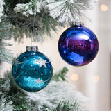 Blue star ornament and purple glass ornaments hanging on Christmas tree