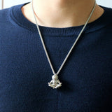 Man wearing an astronaut pendant showing a spaceman meditating. The perfect space gift!