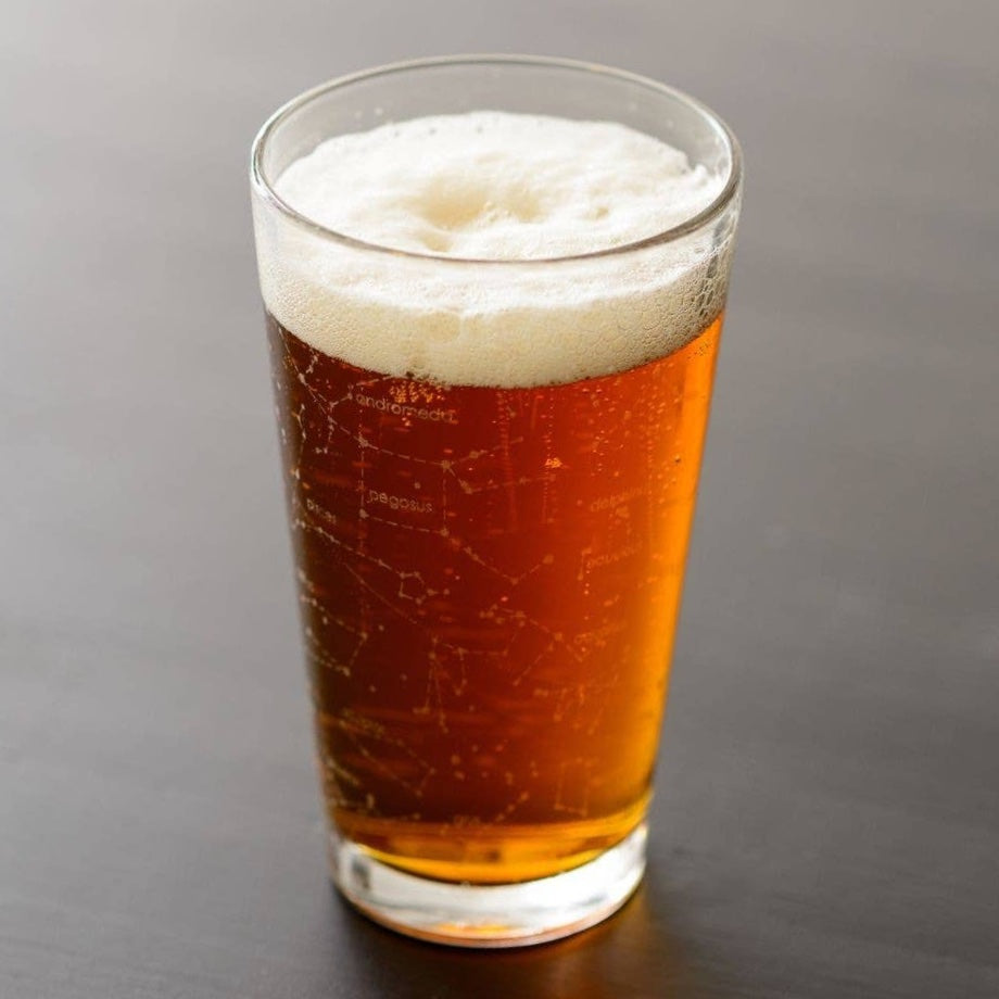 Outer space themed beer pint glass showing northern summer night sky zodiac constellations