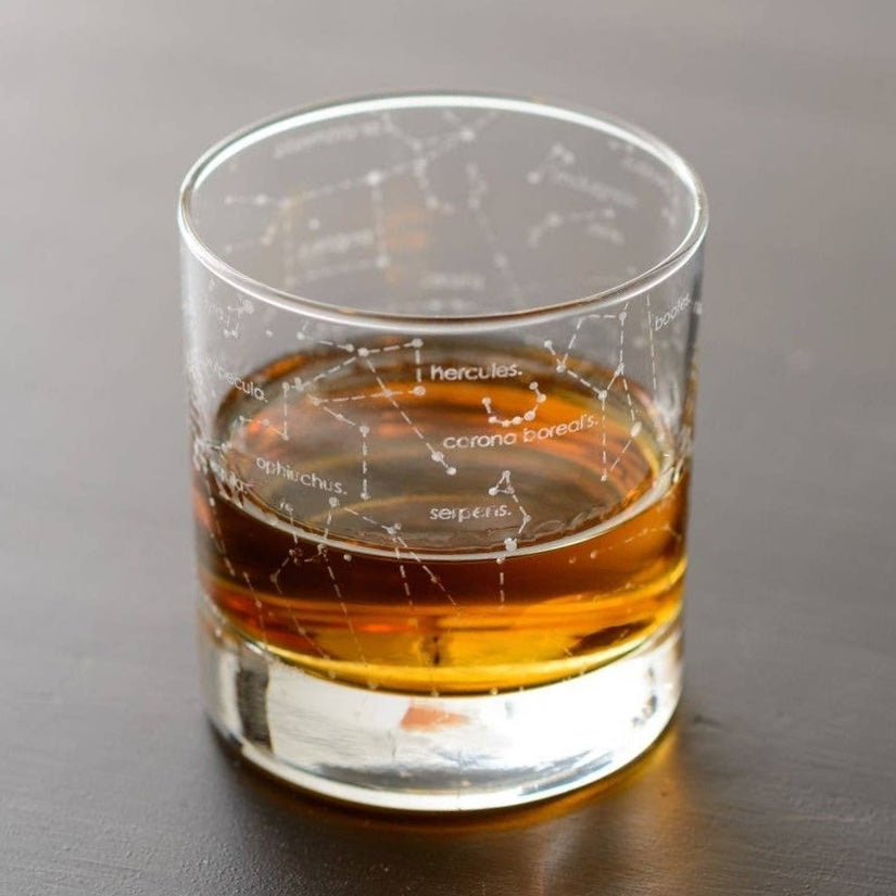 Outer space themed whiskey rocks glass showing northern summer night sky zodiac constellations