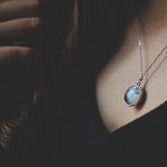 Two-sided full moon necklace with glass dome showing near and far side of the moon