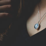 Two-sided full moon necklace with glass dome showing near and far side of the moon