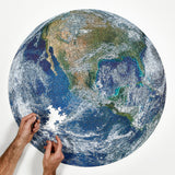A round earth puzzle by Four Point Puzzles - the perfect space gift! Shows someone building the puzzle.