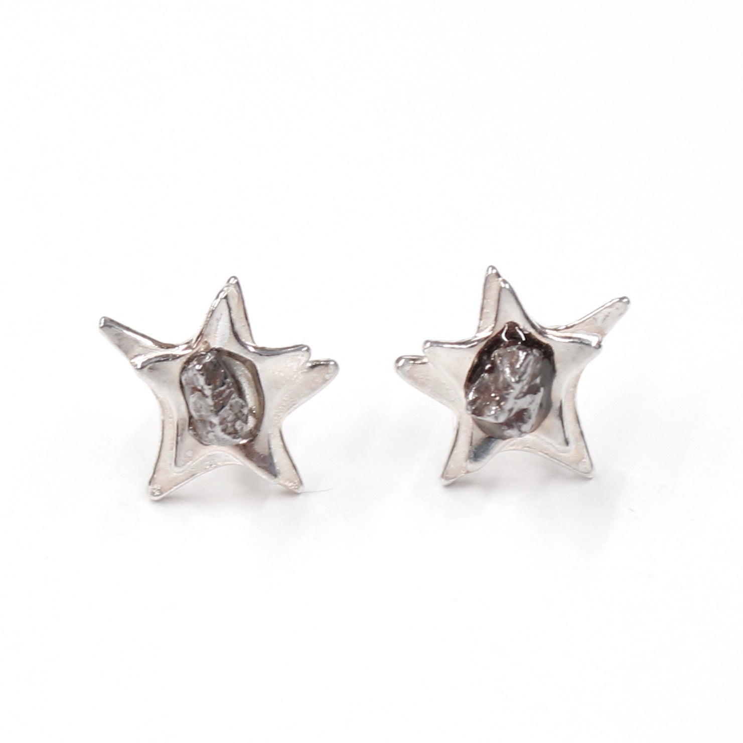 Space jewelry earrings in sterling silver with star shape and campo del cielo meteorite in center.