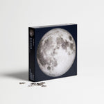 moon puzzle from Four Point Puzzles with 1000 pc round design. A space gift for space enthusiasts! Shows front of box with loose puzzle pieces.