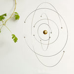 Spinning space and science mobile next to plant