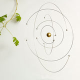 Spinning space and science mobile next to plant