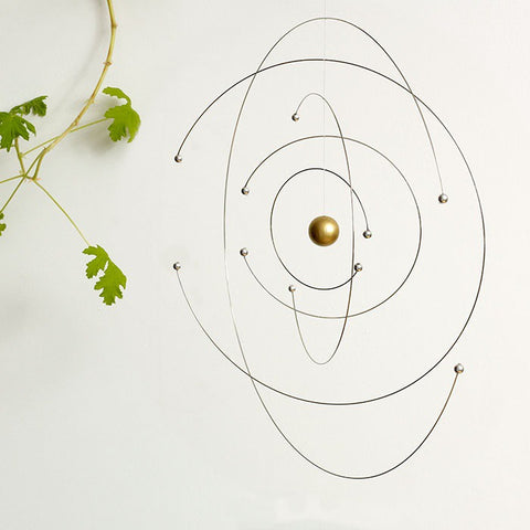 Spinning space and science mobile next to plant