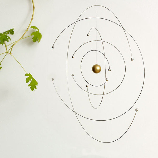 Spinning space and science mobile next to plant